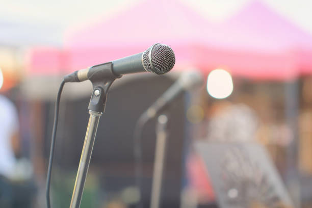 istock Microphone of stage on street with blurred colorful bright light background 952822120