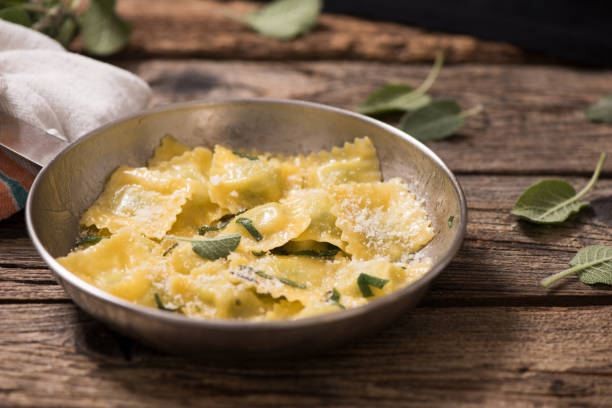 Italian cuisine: ravioli pasta with parmesan cheese and sage stock photo