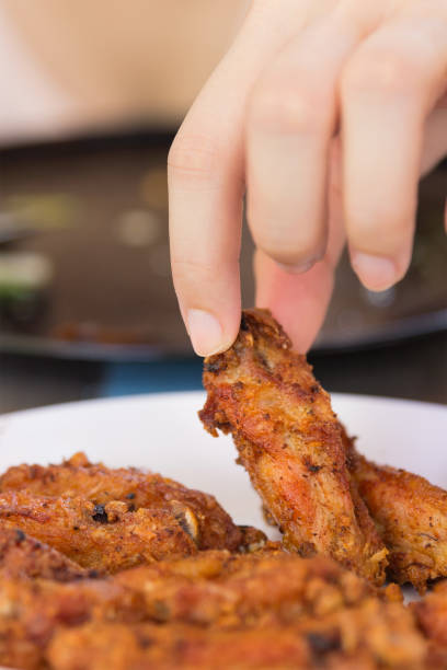 istock A girl holding and eatting fried chicken 952843544