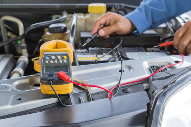 istock Car repair service, Auto mechanic checking a car battery level by voltmeter 952844412