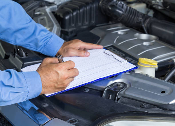istock Car repair service, Auto mechanic checking car engine, writing checklist on clipboard 952845022