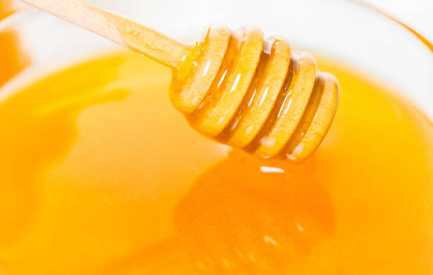 istock wooden spoon in honey closeup 952845332