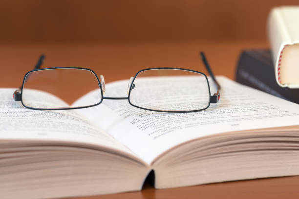 istock Eyeglasses on an Open Book on a Wooden Background 952852384