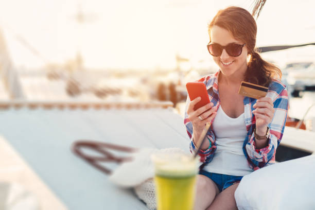 istock Woman in hammock shopping online 952852448