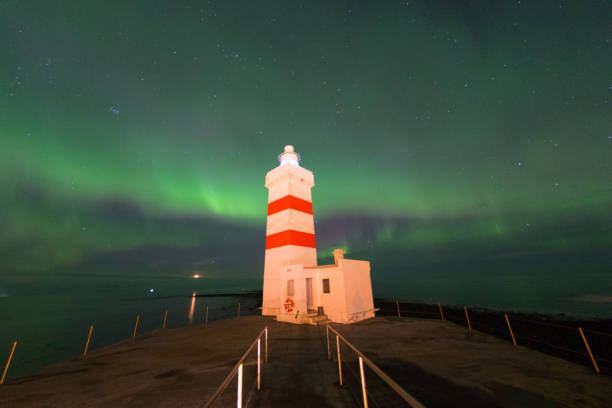 Green and white lighthouse on the Baltic Sea. Waves on the stone edge. A great signal for shipping. Landscape photo from Germany