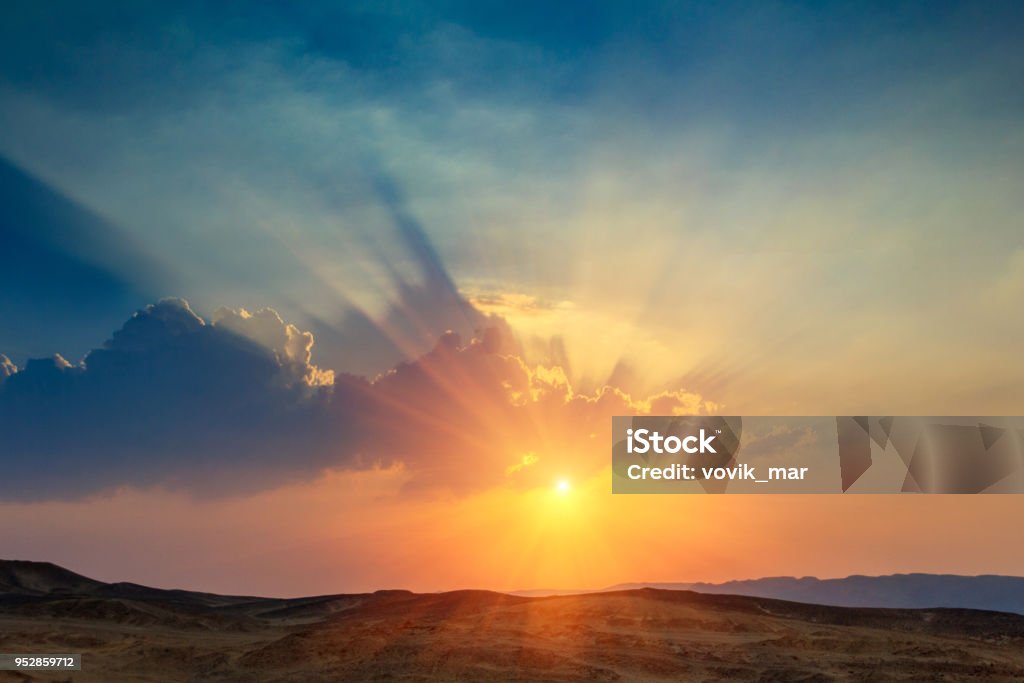 Landscape of beautiful sunset in the desert. Sinai Peninsula. Landscape of beautiful sunset in the desert. View of  high sandstone hills and  dramatic cloudy sky. Sinai Peninsula. Sunset Stock Photo