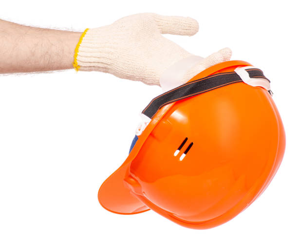 istock Orange man's helmet man's hand in a glove 952871214