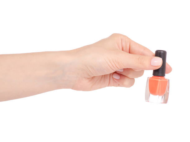 istock Orange nail polish in hand 952877572