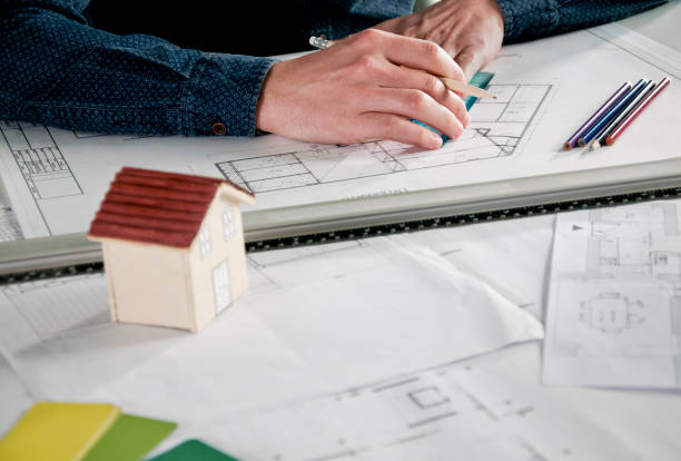 istock Architect working in office with house project on desk 952893408