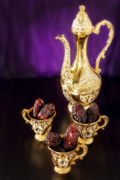 istock Still life with dates with goldenTraditional Arabic coffee set with dallah and mini cup. Dark background. Vertical photo. Toned photo. 952902154