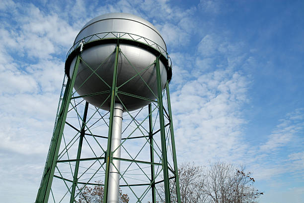 Water tower with green structure against sky stock photo