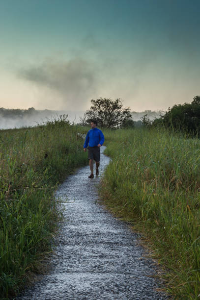 istock Man walking towards on footpath in the wet 952922092