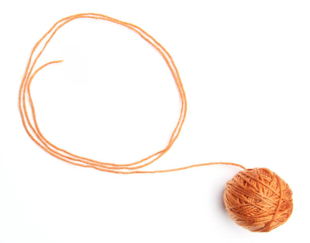 istock Orange thread ball with frame made of thread isolated on white background. 952940592