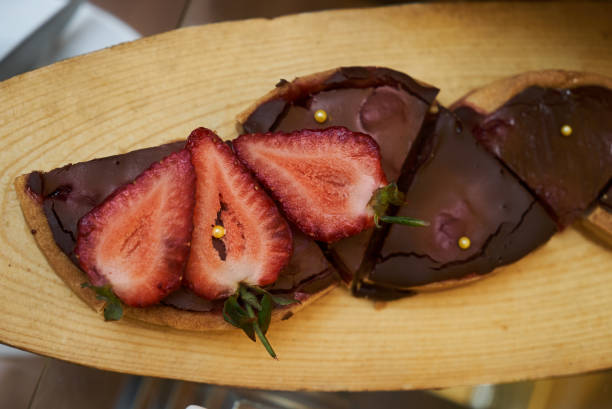 istock Chocolate cake with strawberry on wooden cake board 952946236