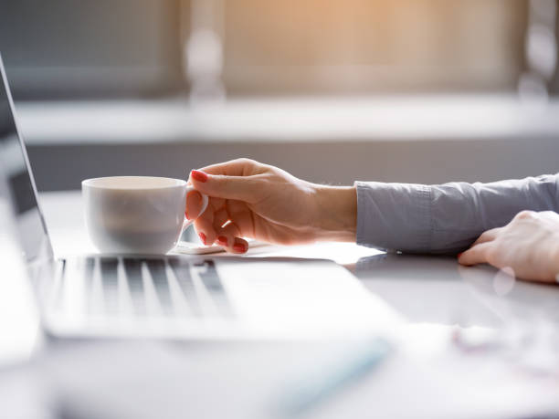 istock Young businesswoman drinking hot beverage near computer 952950032