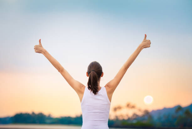 Winning, success  and life goals concept. Young woman with arms in the air giving thumbs up. positive emotion stock pictures, royalty-free photos & images