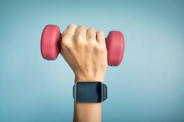 Hand wearing smartwatch and holding weight.
