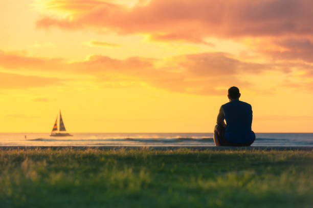 Men watching the sunrise Men watching the sunrise at the beach. Location Hawaii. one man only stock pictures, royalty-free photos & images