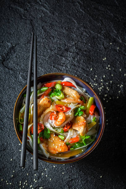 istock Hot noodle in dark bowl with chopsticks on black rock 952959018