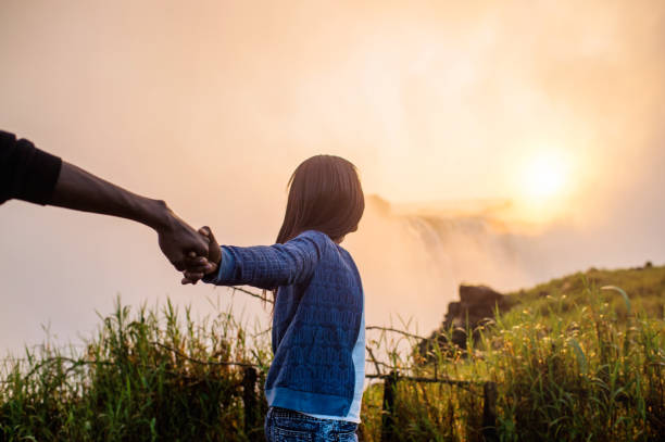istock Holding hands looking at Victoria Falls 952964990
