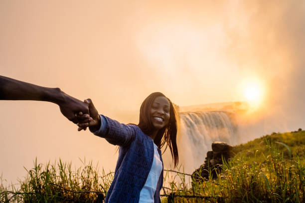 istock Beautiful African girl pulling someone towards Victoria Falls 952965648