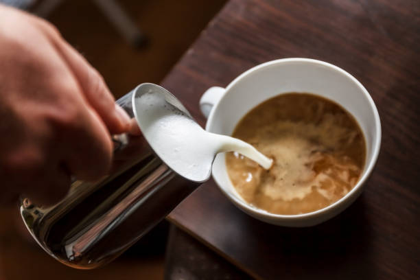 istock man pouring into a cup of coffee with milk 952969406