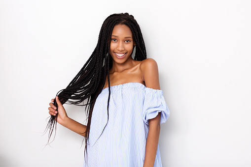 Portrait of beautiful african american woman with braided hair smiling against white background