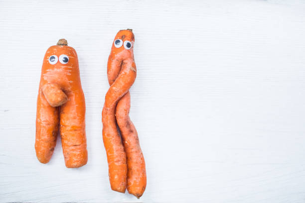 istock Funny shape of carrot with eyes on white board background. Copy space 952970134