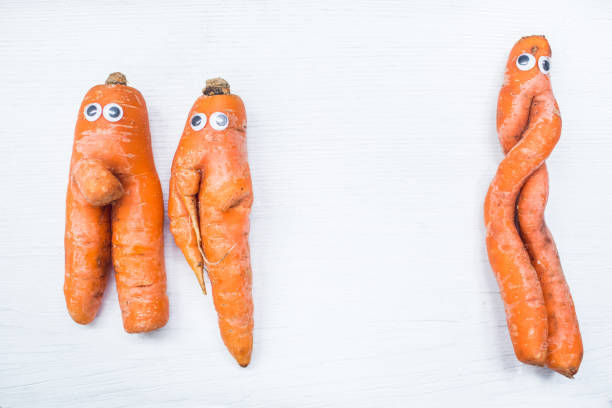 istock Funny shape of carrot with eyes on white board background. Copy space 952970136