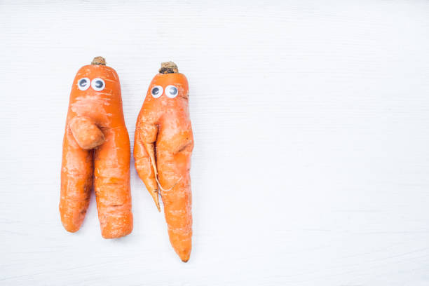 istock Funny shape of carrot with eyes on white board background. Copy space 952970140