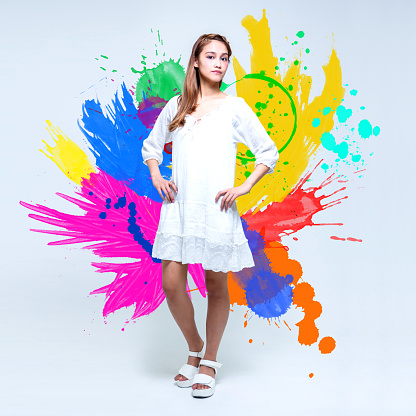Portrait of young girl standing in front of colorful painted background.