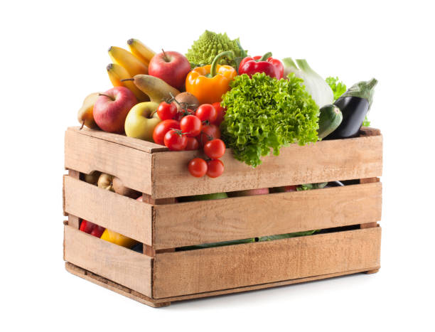 фрукты и овощи в деревянном ящике на белом фоне - basket of fruits стоковые фото и изображения