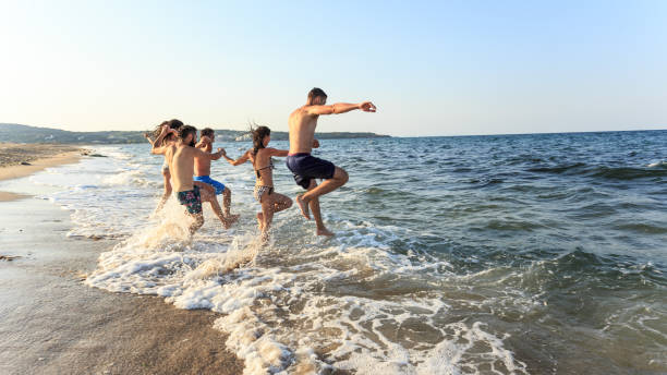 istock Friends jumping in the sea 953009662