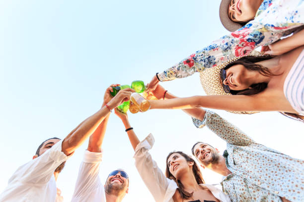 istock Friends cheering with beer on beach 953009668