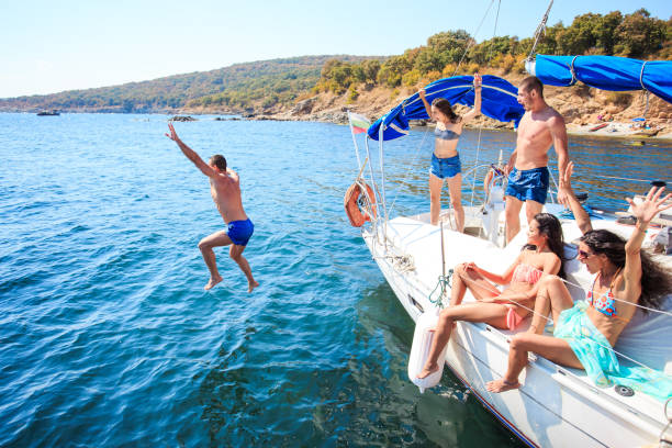 istock Young people jumping from yacht 953009798