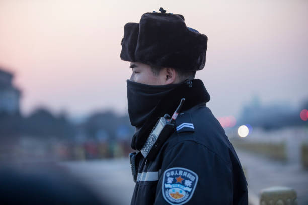 Policeman standing in Tiananmen Square, waiting for the flag ceremony, just before the sunset.. The Flag Ceremony is hold every sunrise and sunset.