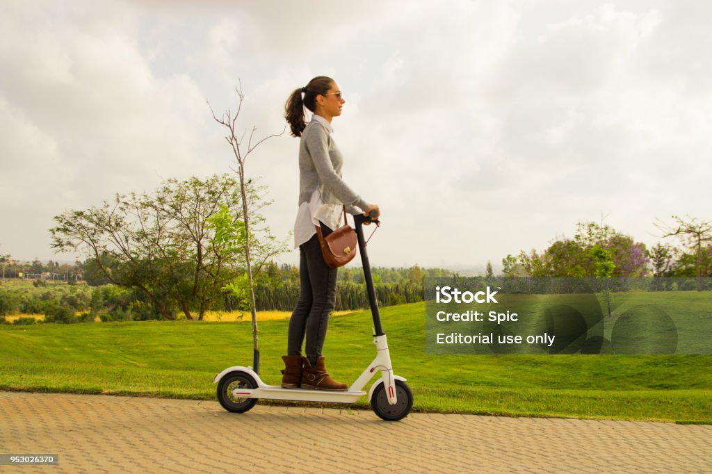 A young women with an electric scooter in the park Ramat gan israel, April 21 2018, A young women with an electric scooter in the park Electric Push Scooter Stock Photo