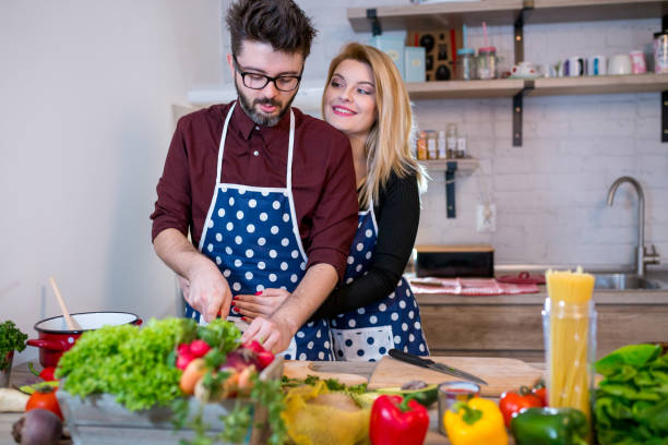 istock Smiling young couple cooking food in the kitchen 953027366