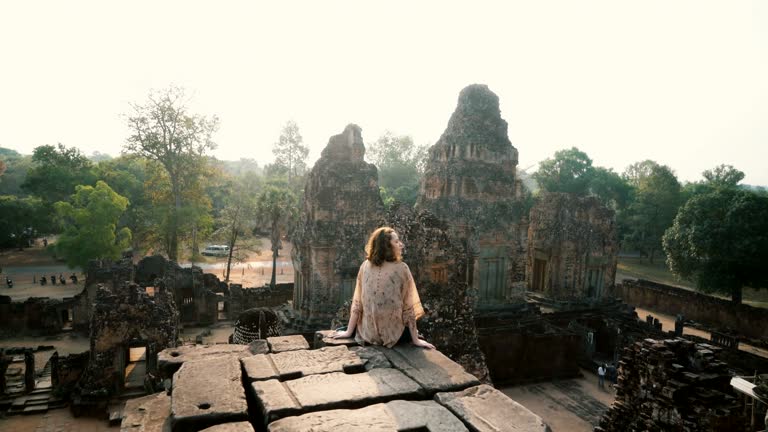 Woman sitting  and looking at view  in Angkor Temple in Cambodia