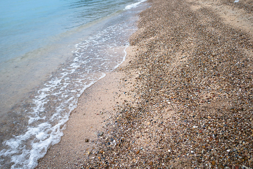 Sea waves on the beach with full of stones, use for background. Select focus shallow depth of field
