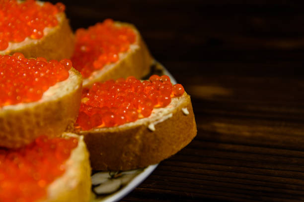 istock Sandwiches with red caviar on wooden table 953045116