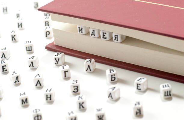 istock word idea written win cyrillic letters between book sheets and cyrillic letters scatter on white background concept abstract 953049476