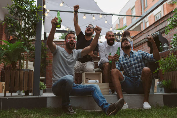 istock Friends Watching Soccer Game On Big Screen In Backyard 953053562