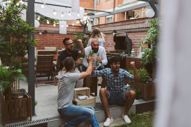 istock Friends Watching Soccer Game On Big Screen In Backyard 953055950