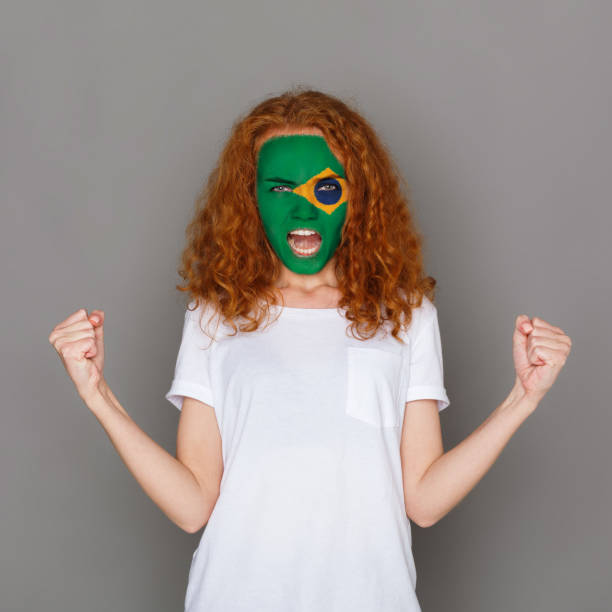 istock Young woman with Brasil flag painted on her face 953058128