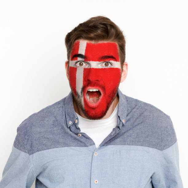 Young man with Denmark flag painted on his face