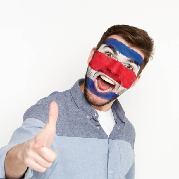 istock Young man with Costa Rica flag painted on his face 953058324