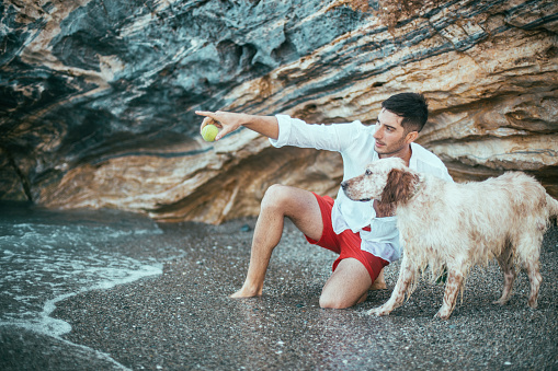 Man playing with his dog on the beach
