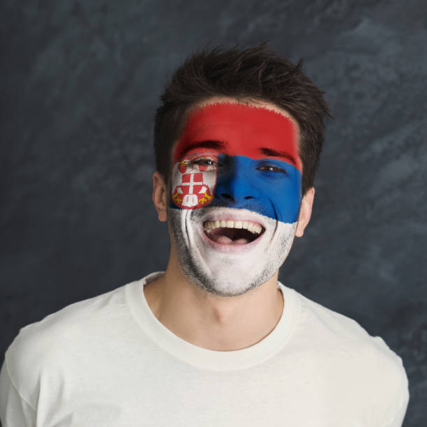 istock Young man with Serbia flag painted on his face 953058486