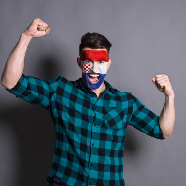istock Young man with Croatia flag painted on his face 953058558